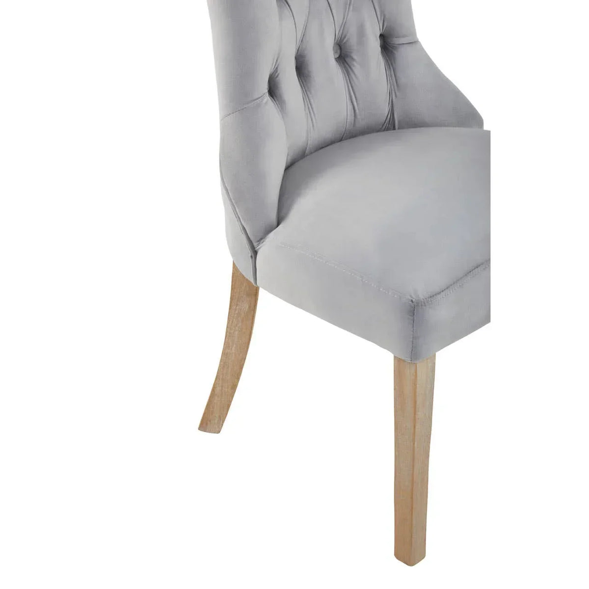 Grey velvet dining chair with button tufted back and wooden legs, side view