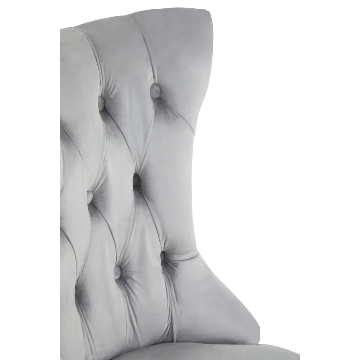 Light grey velvet chair featuring button-tufted backrest and curved wingback design