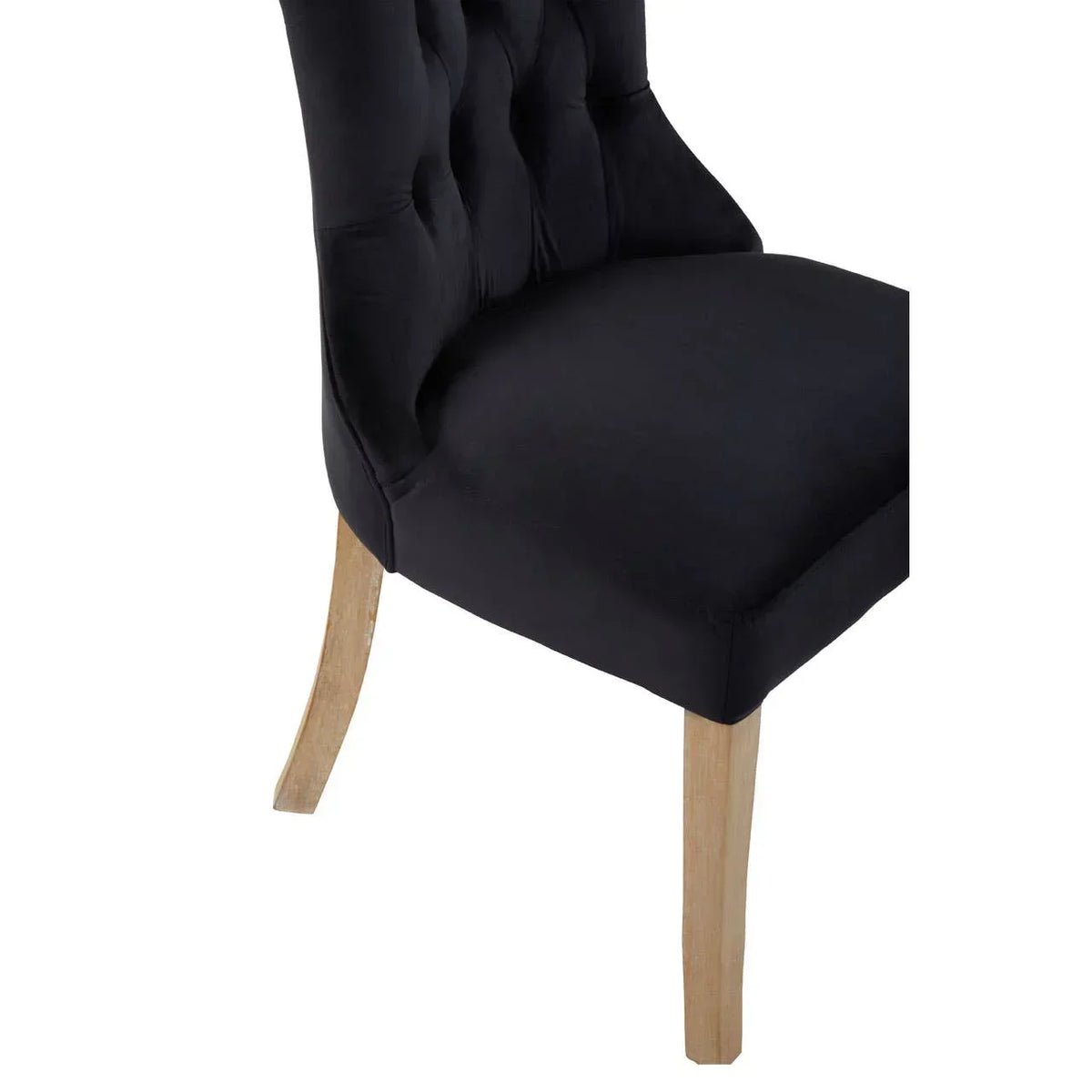 Black upholstered dining chair with buttoned back and light wooden legs, side angle view