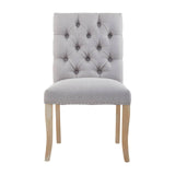 Grey upholstered dining chair with button tufted back and wooden legs, front view