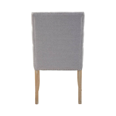 Grey fabric dining chair with wooden legs, rear view showing nailhead trim detail