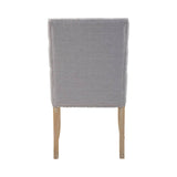 Grey fabric dining chair with wooden legs, rear view showing nailhead trim detail