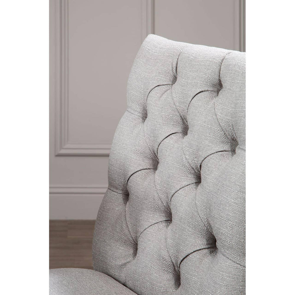 Light grey fabric dining chair with deep button tufted backrest, closeup angle