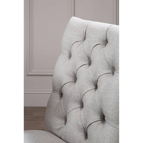 Light grey fabric dining chair with deep button tufted backrest, closeup angle