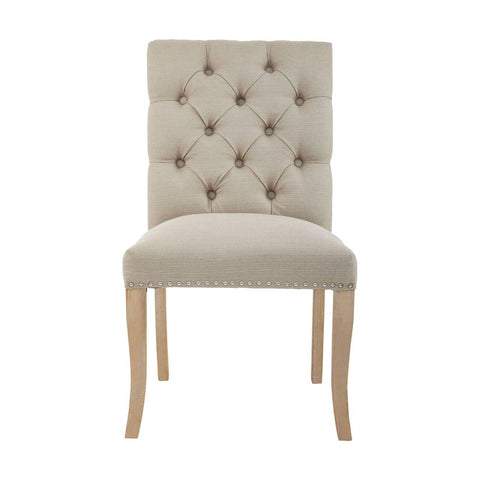 Beige upholstered dining chair with button tufted back and nailhead trim, light wood legs