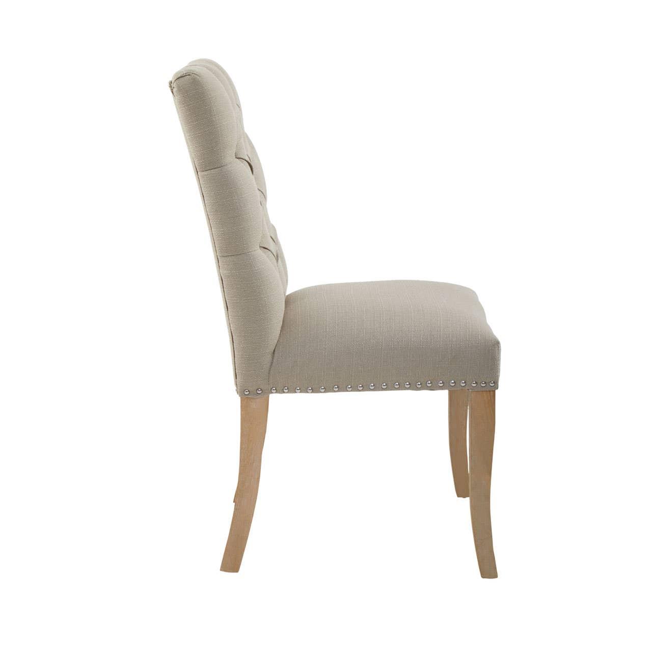 Beige upholstered dining chair with tufted back and natural wood legs, side profile view