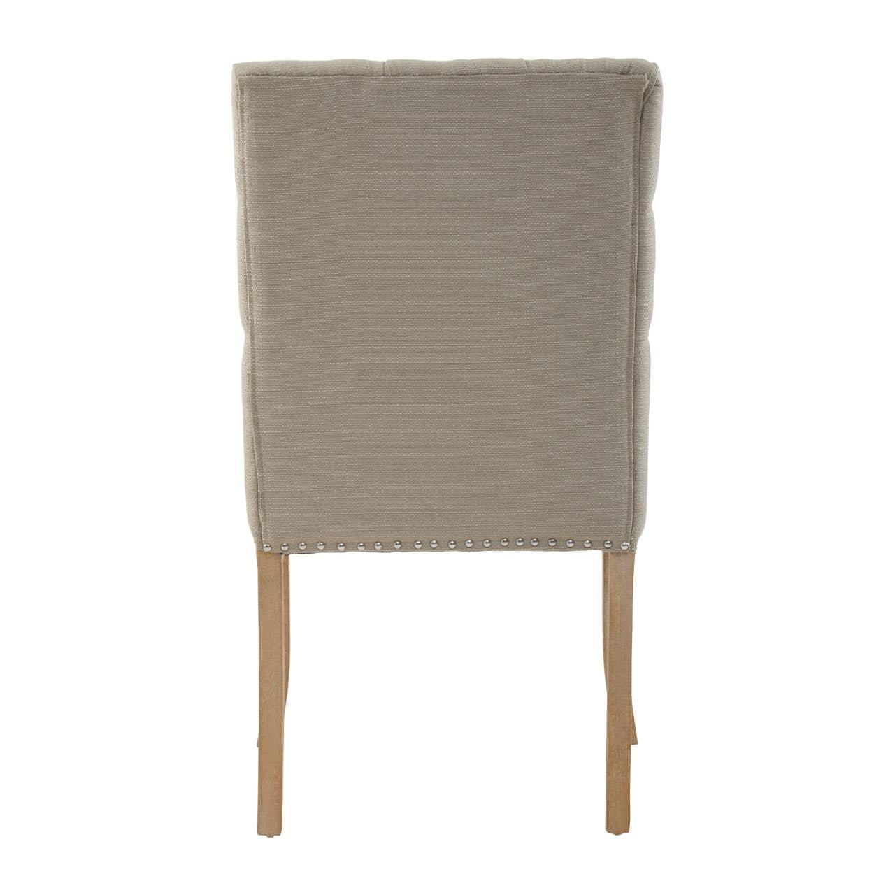 Beige upholstered dining chair rear view with wooden legs and silver stud detailing