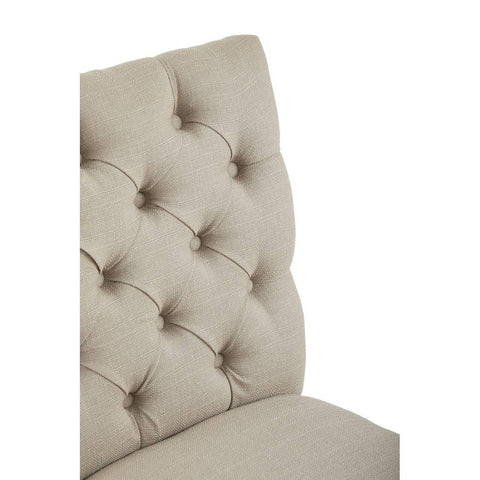 Beige fabric dining chair with deep button tufted backrest close up