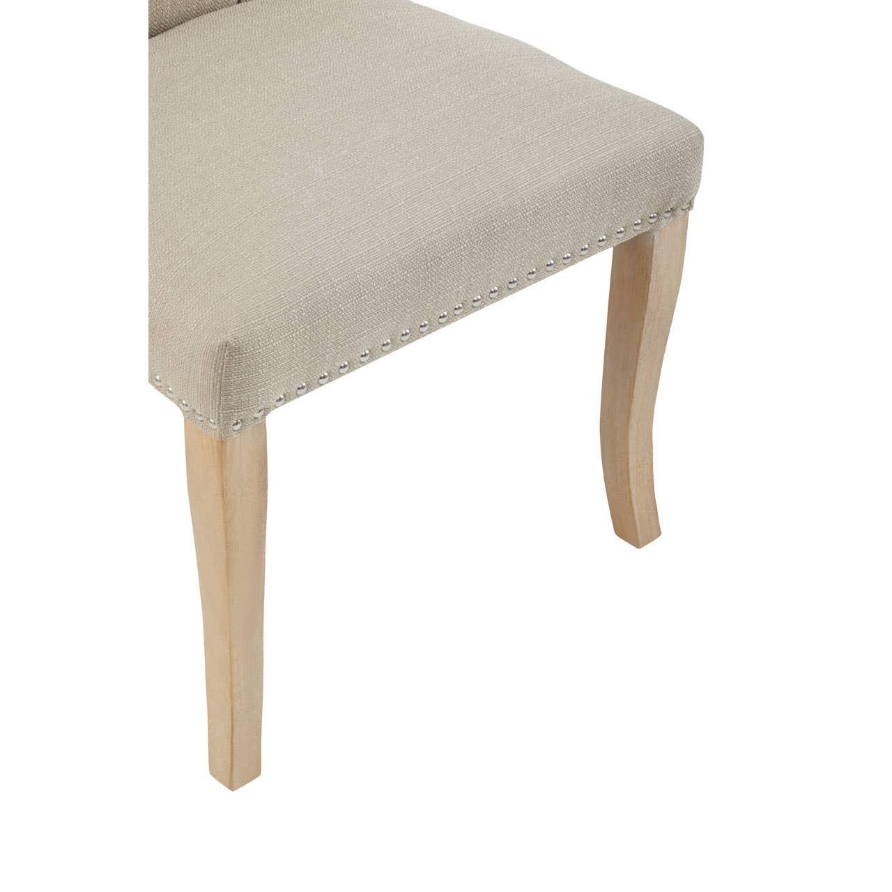 Beige upholstered dining chair seat with nailhead trim and wooden legs