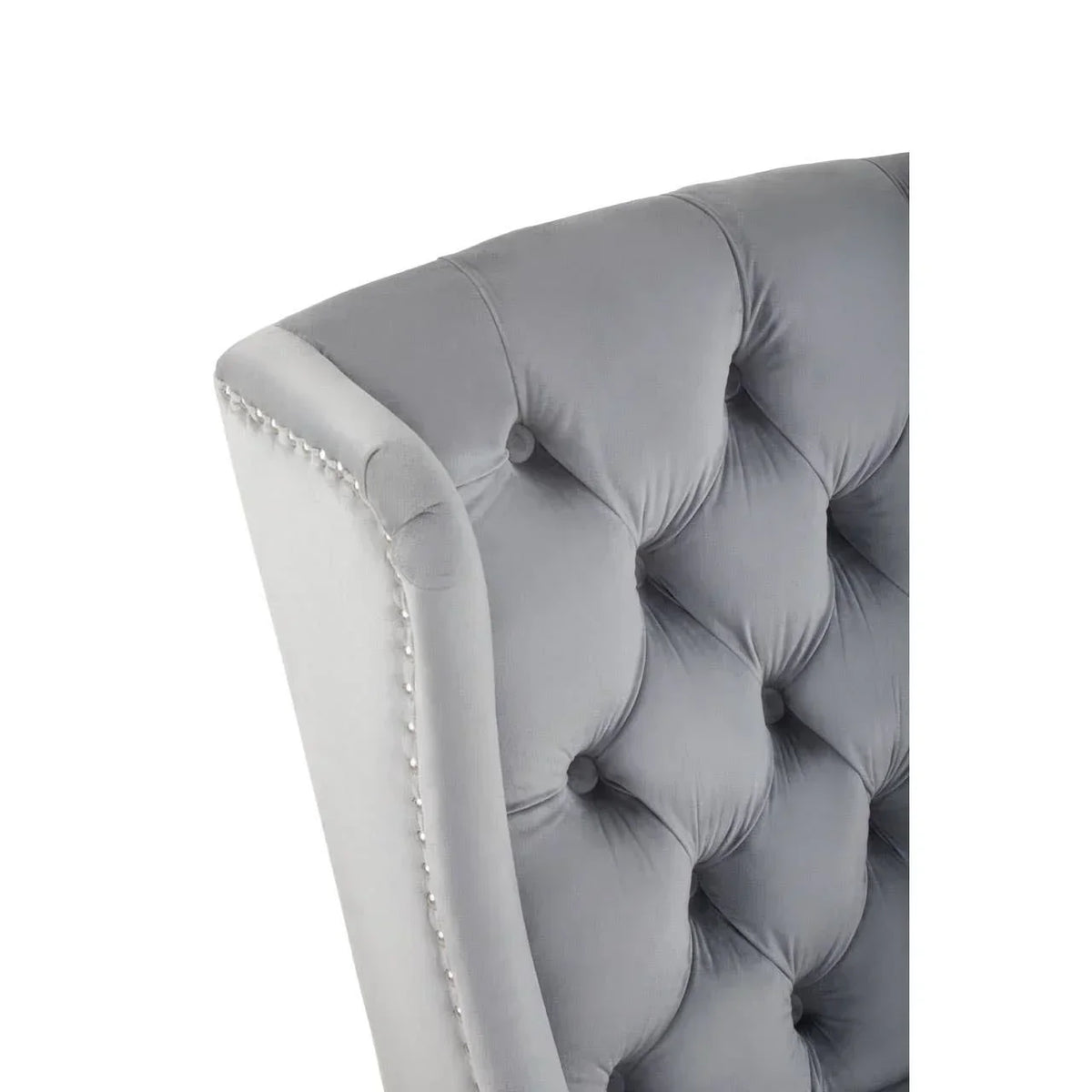 Grey velvet dining chair with deep button tufting and silver studded trim detail