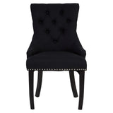 Black upholstered dining chair with tufted back and silver stud detailing, front view