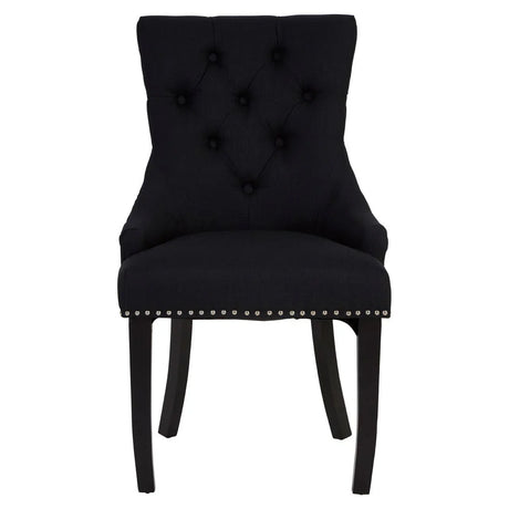 Black upholstered dining chair with tufted back and silver stud detailing, front view