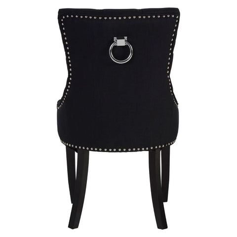 Black dining chair with chrome ring handle, silver stud trim, and dark wooden legs, rear view