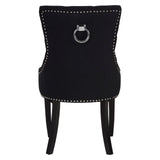 Black dining chair with chrome ring handle, silver stud trim, and dark wooden legs, rear view
