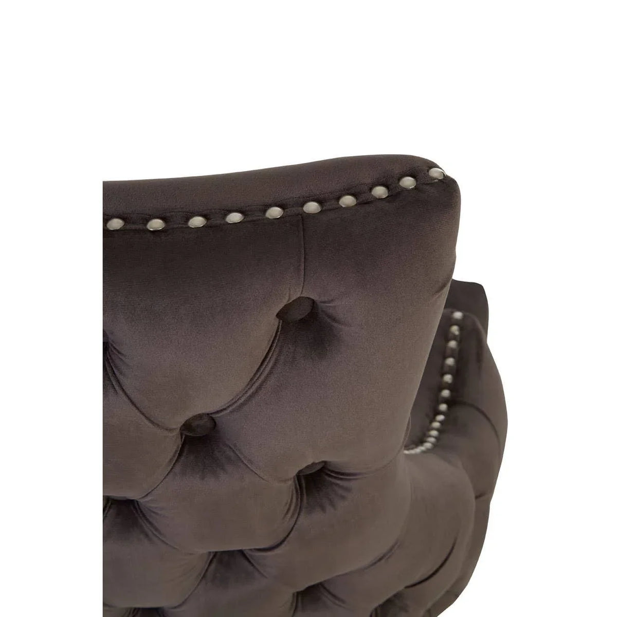 Dark tufted velvet chair back with silver stud detail and plush upholstery