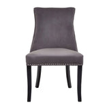 Grey velvet dining chair with studded trim and black wooden legs, front view