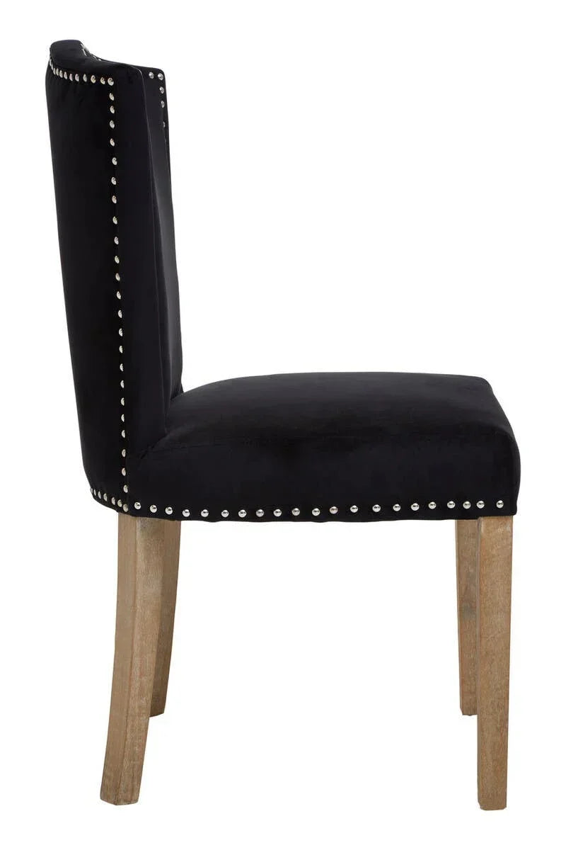 Black velvet dining chair with silver stud detailing and light wood legs, side view