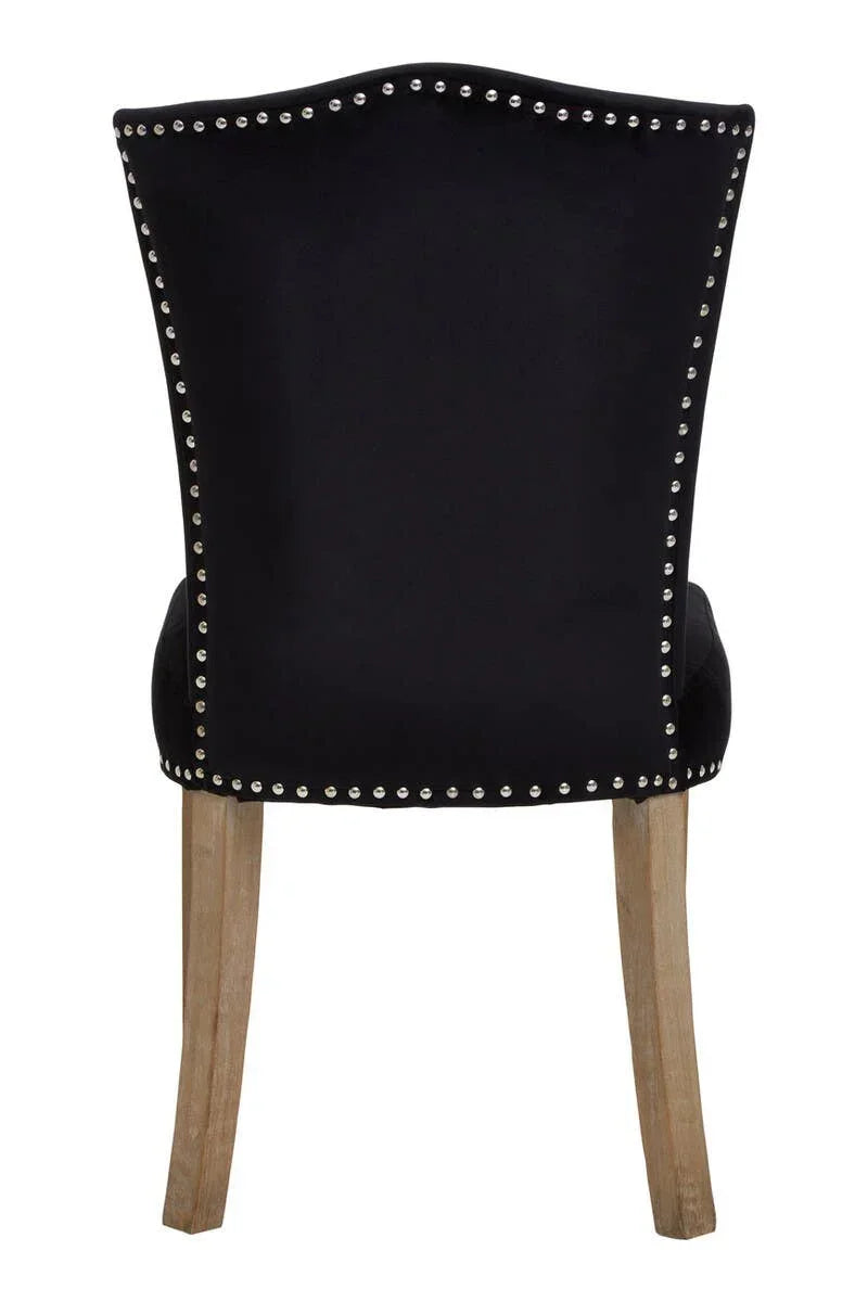 Black velvet dining chair back view with silver studs and wooden legs