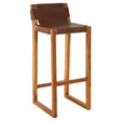 Brown leather bar chair featuring a sleek design with a sturdy teak wood frame. The chair has a high backrest and a minimalist structure, emphasizing natural wood tones and a modern aesthetic