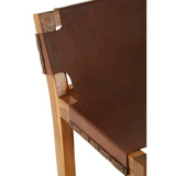 Brown leather bar chair featuring a sleek design with a teak wood frame. The chair's backrest is slightly angled and showcases a smooth leather finish, while the wooden legs provide sturdy support. The craftsmanship highlights the natural grain of the teak wood, enhancing the overall aesthetic