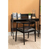 Black wooden desk and matching chair with leather seat, styled with decor in modern home office