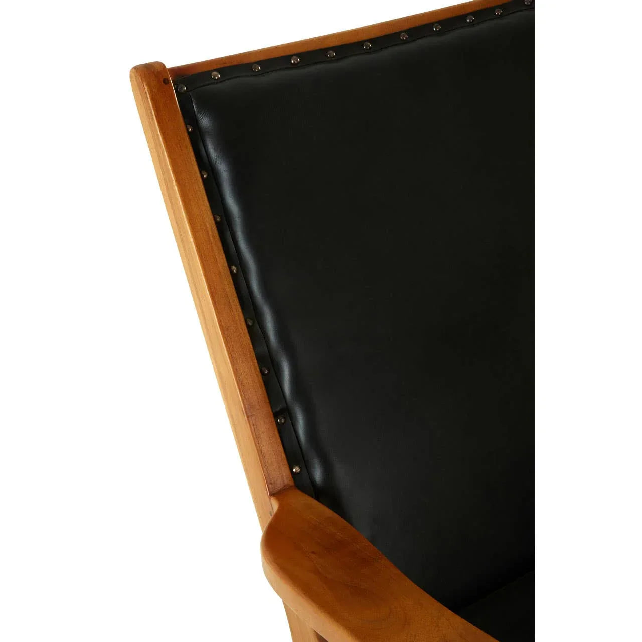 Close-up of wooden armchair with black leather backrest and metal stud detailing