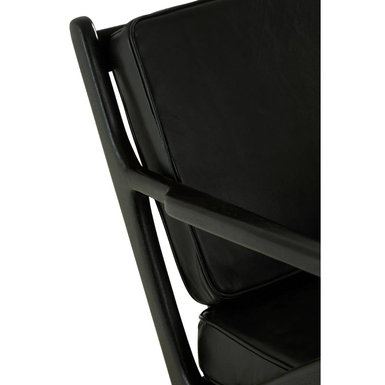 Close-up view of the Kendari armchair showcasing the black leather seat and backrest, with a sleek teak wood frame. The armchair features clean lines and a modern design, highlighting the contrast between the dark leather and the natural wood finish