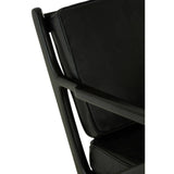 Close-up view of the Kendari armchair showcasing the black leather seat and backrest, with a sleek teak wood frame. The armchair features clean lines and a modern design, highlighting the contrast between the dark leather and the natural wood finish