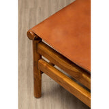 Corner view of wooden chair with tan leather seat on laminate flooring