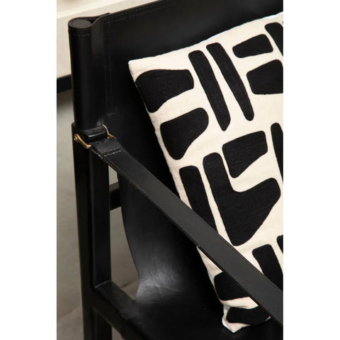 Black leather accent chair with modern black and white patterned cushion
