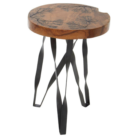 Round teak wood stool featuring intricate carvings on the top surface, supported by sleek black metal legs that have a unique, artistic design. The natural wood finish highlights the grain and texture of the teak
