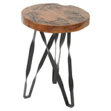 Round teak wood stool featuring intricate carvings on the top surface, supported by a sleek black metal base with curved legs. The natural wood finish highlights the grain and texture of the teak
