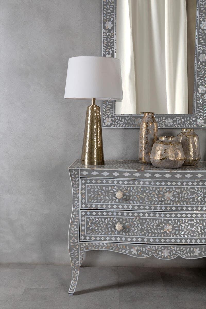 Bone inlay chest of drawers with floral pattern, brass table lamp and decorative vases