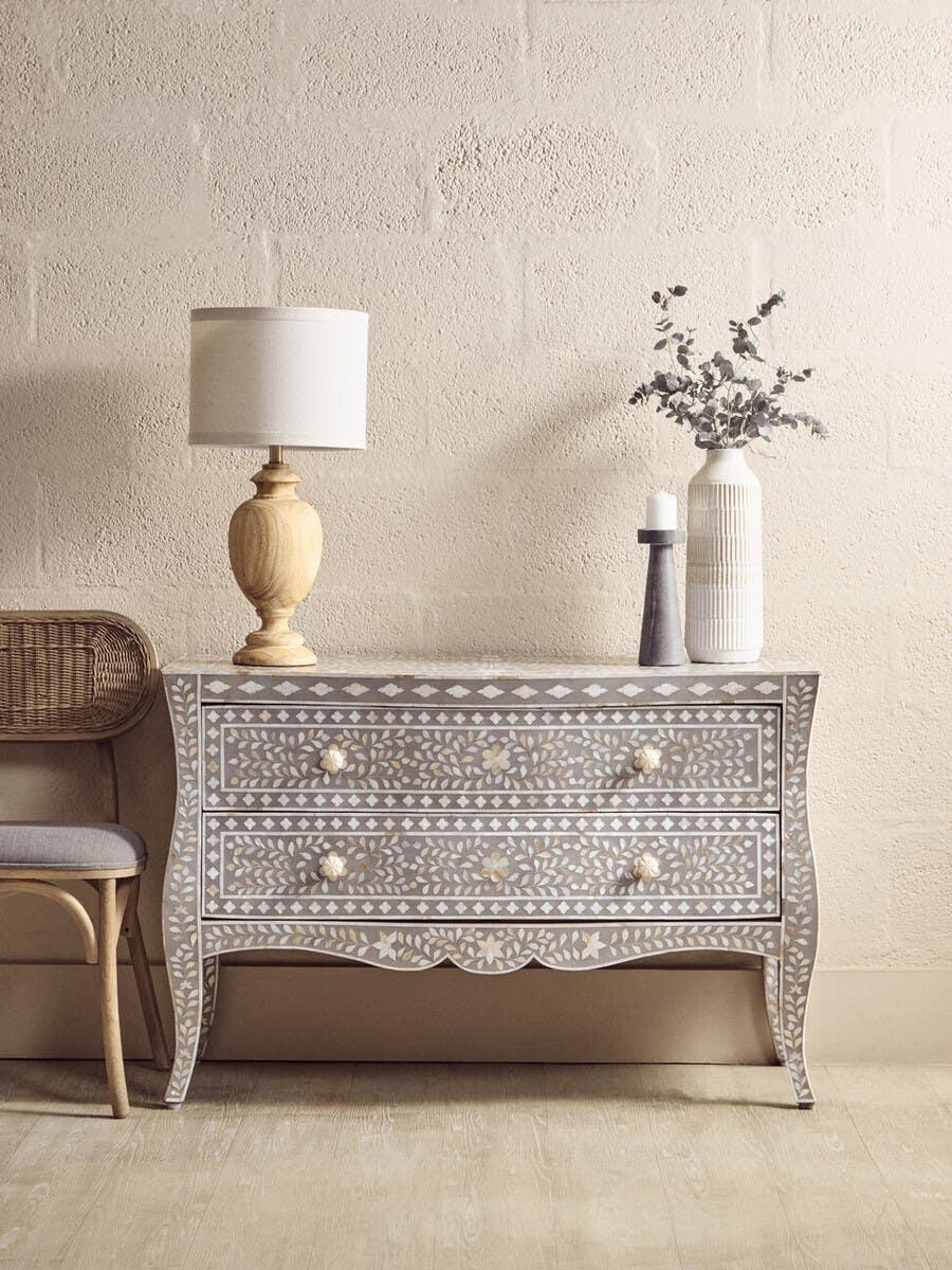 Grey bone inlay chest of drawers with floral pattern, lamp, vase and candle on top