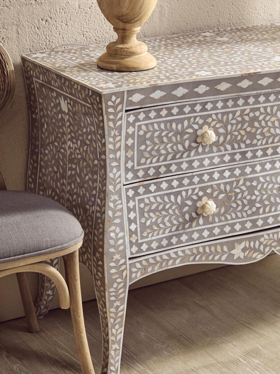 Grey bone inlay chest of drawers with floral pattern and curved legs on wooden floor