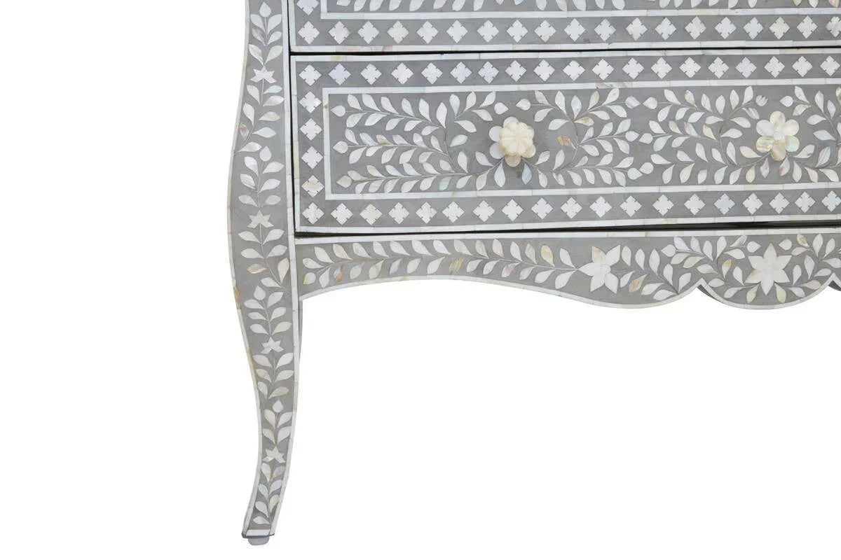 Grey chest of drawers with floral inlay pattern and curved leg design