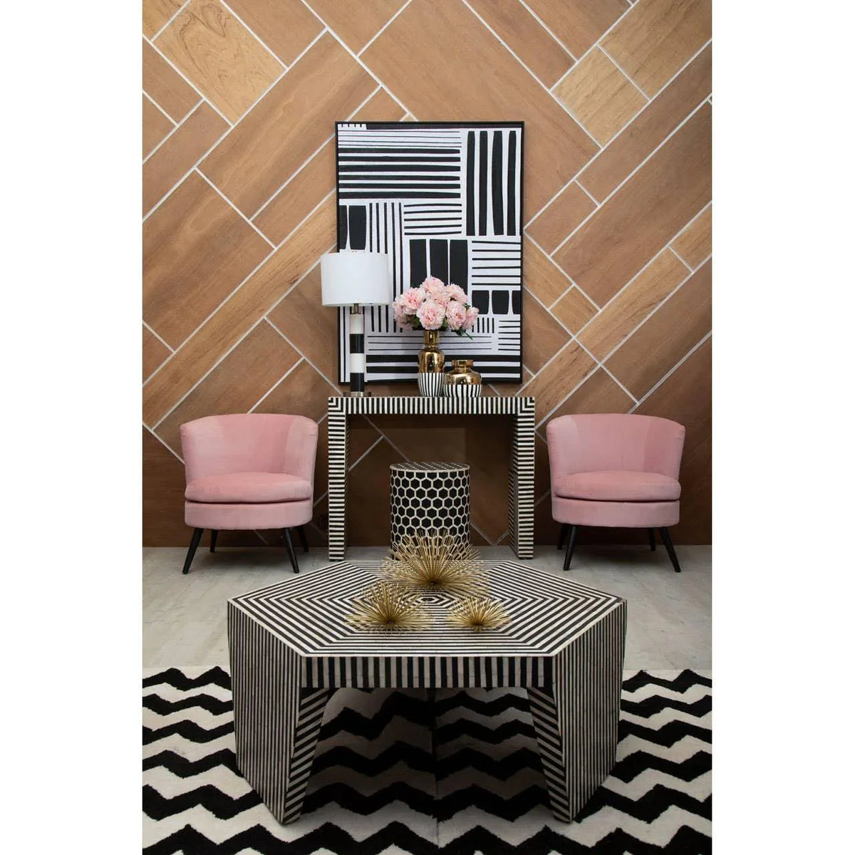 Modern living room with black and white striped coffee table, pink armchairs, geometric decor