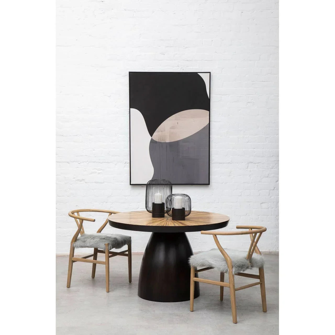 Round wood dining table with pedestal base and two chairs with grey seat cushions