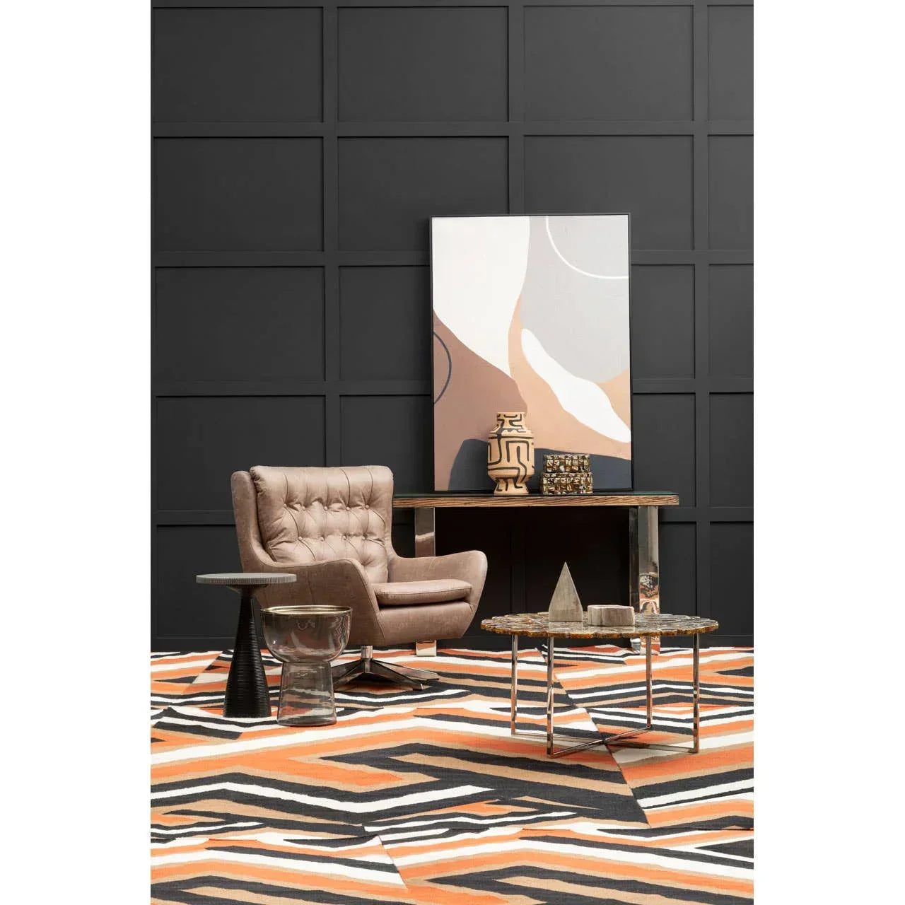 Modern patterned rug with orange, black, and white design under accent chair and coffee table