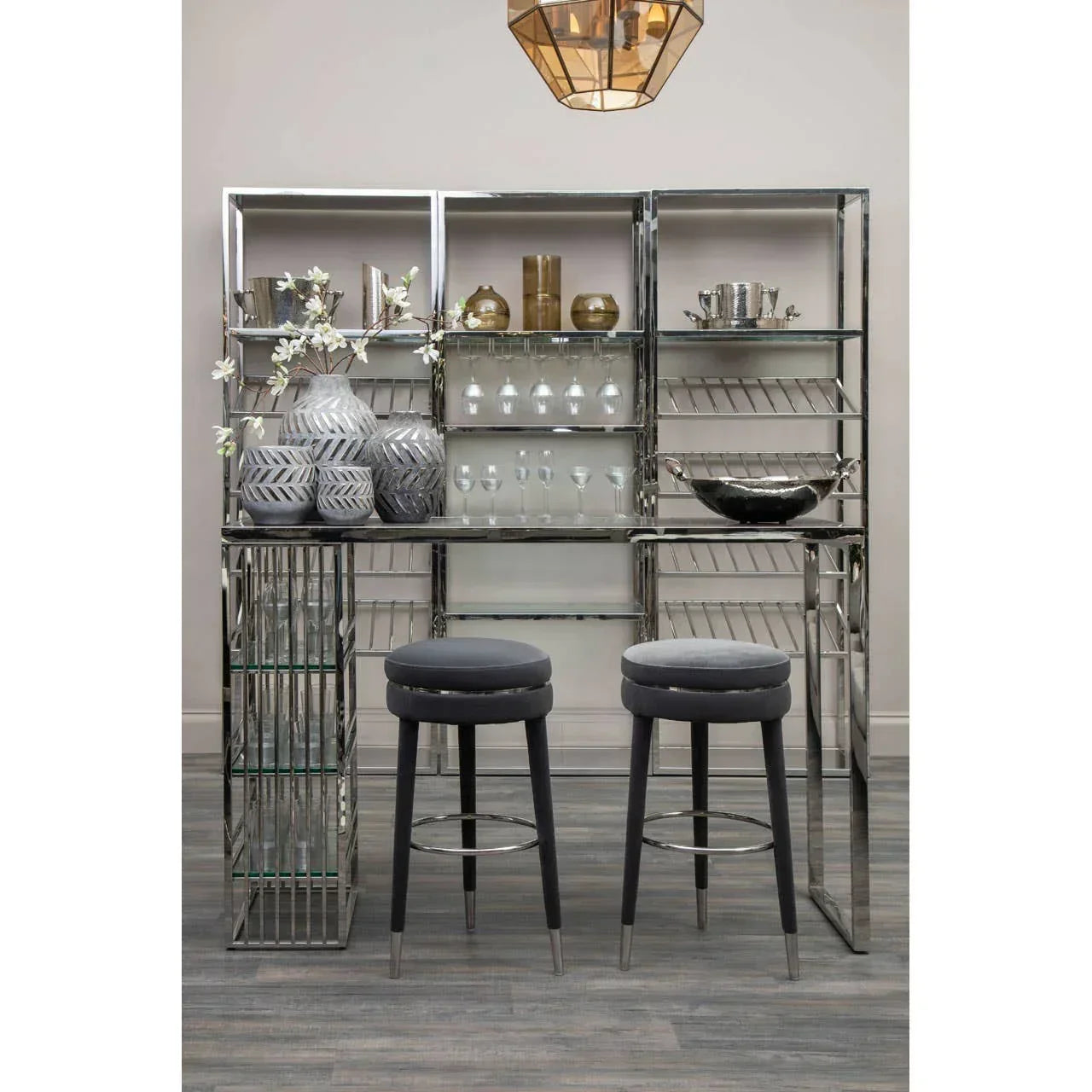 Chrome bar unit with glass shelves, grey bar stools, glassware and decorative vases