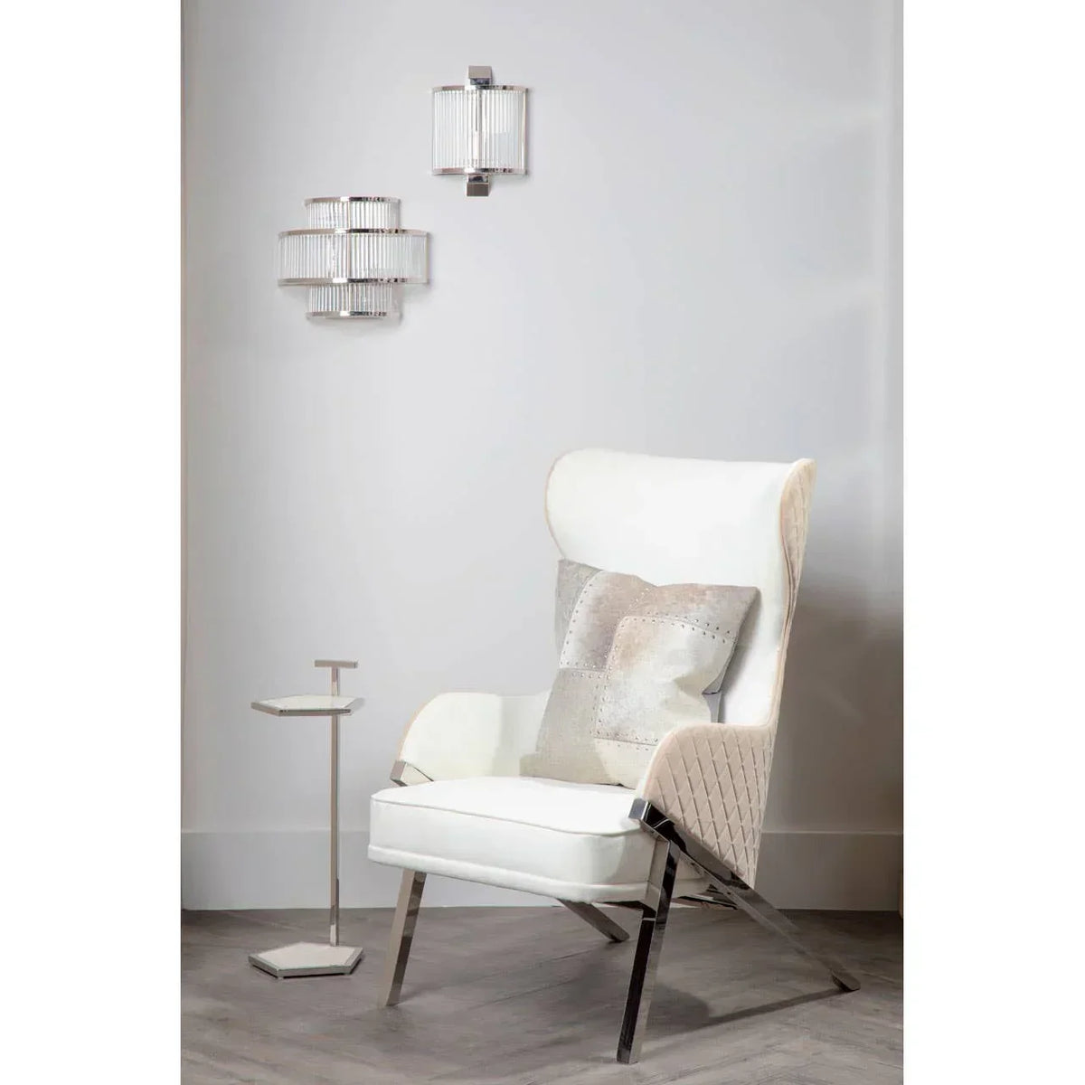 Modern white accent chair with quilted sides, chrome legs, patchwork cushion, and side table
