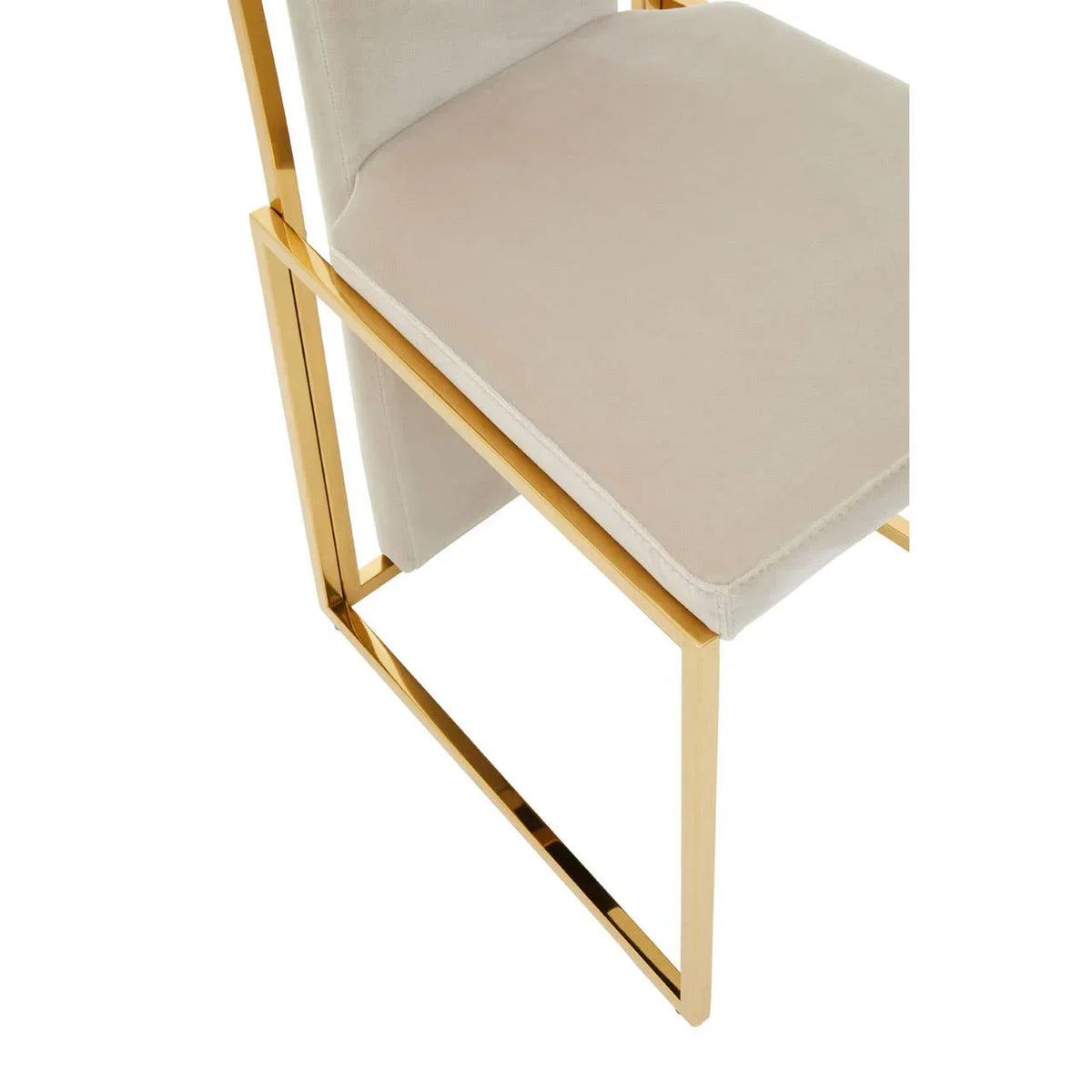 Velvet dining chair with gold metal frame and cream seat close-up