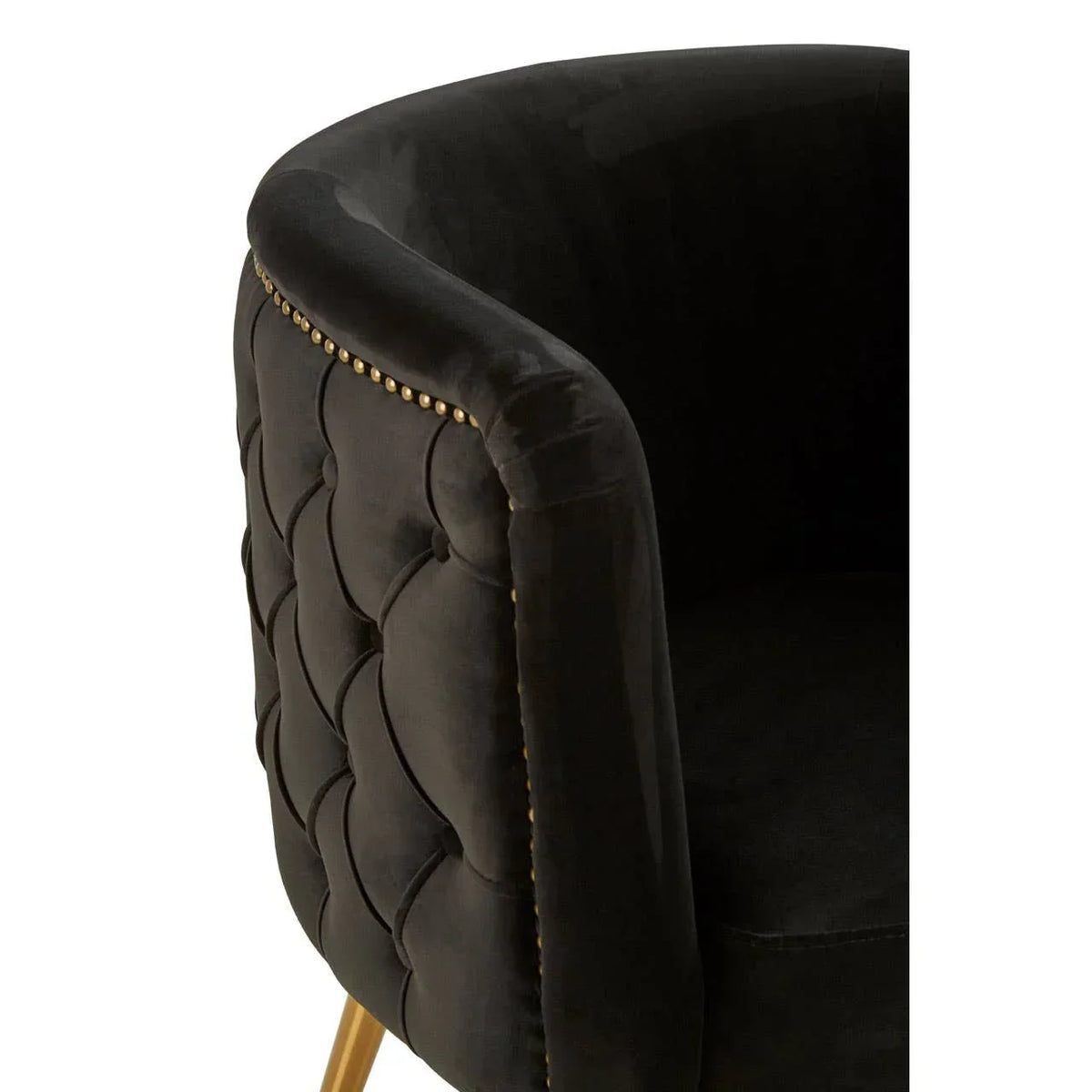 Black velvet armchair with tufted backrest and gold metal legs, close-up corner view