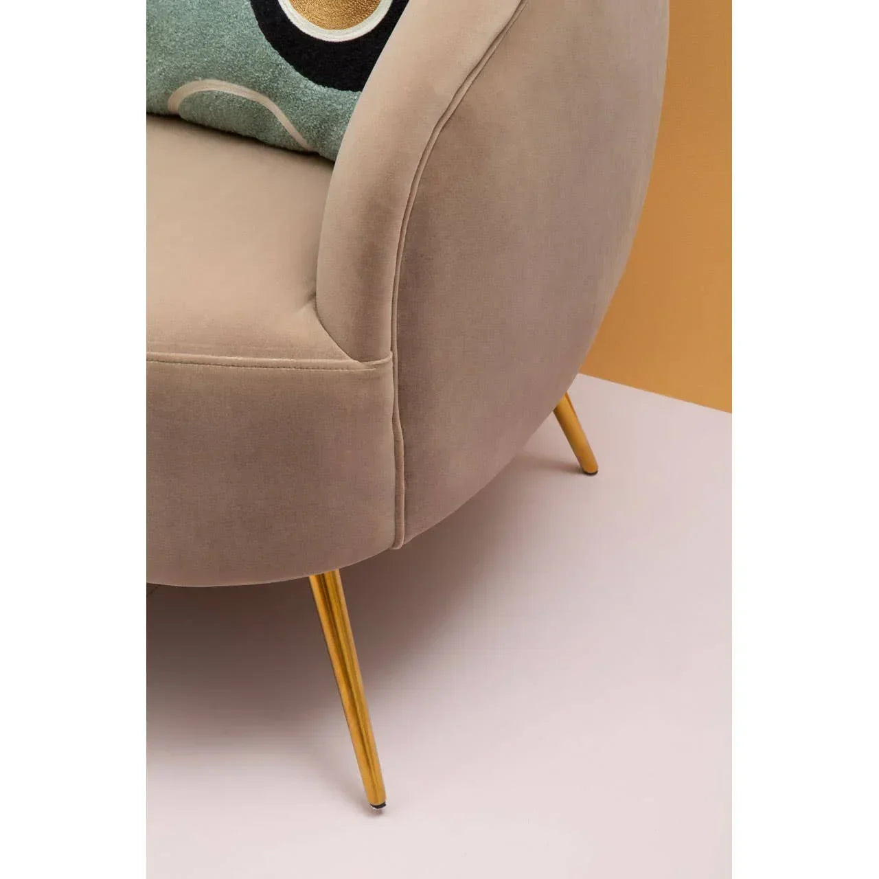 Beige velvet sofa with gold metal legs and rounded armrest, close-up angle