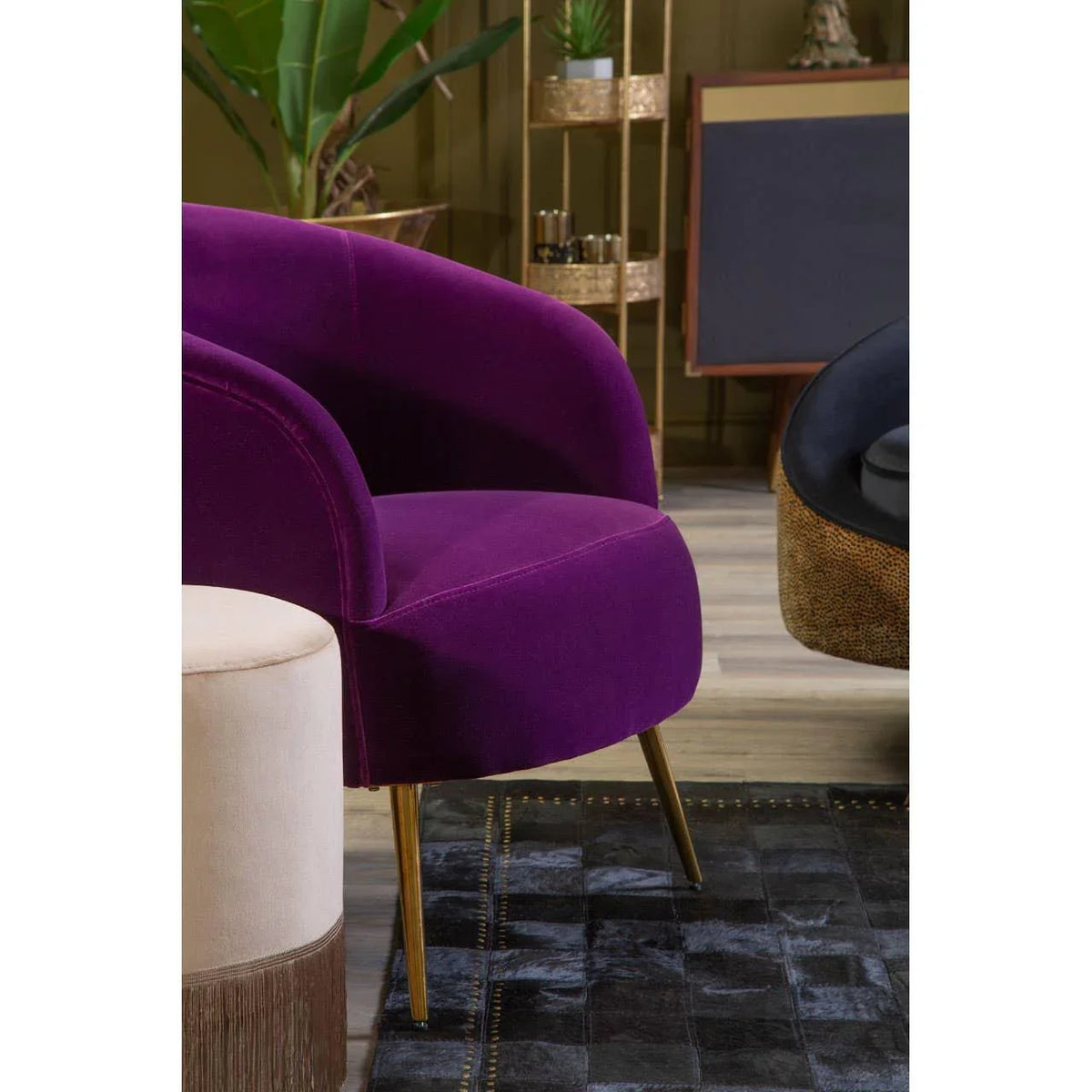 Purple velvet accent chair with gold legs in modern living room setting