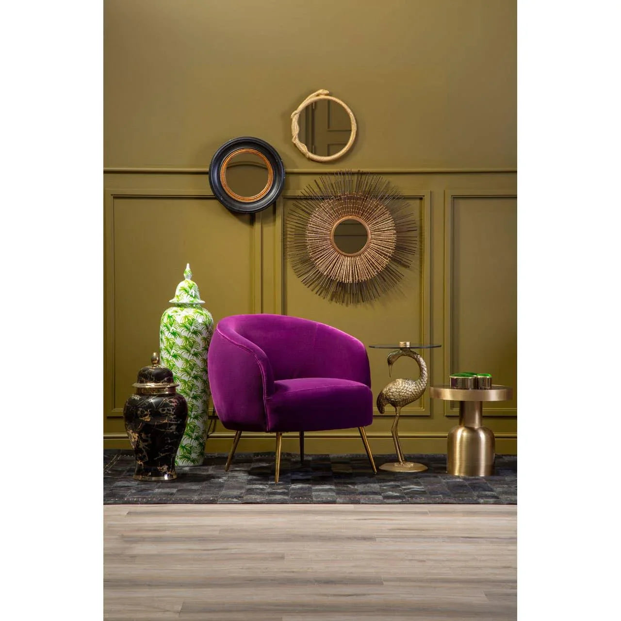 Purple velvet accent chair with gold legs beside decorative jars and brass side tables