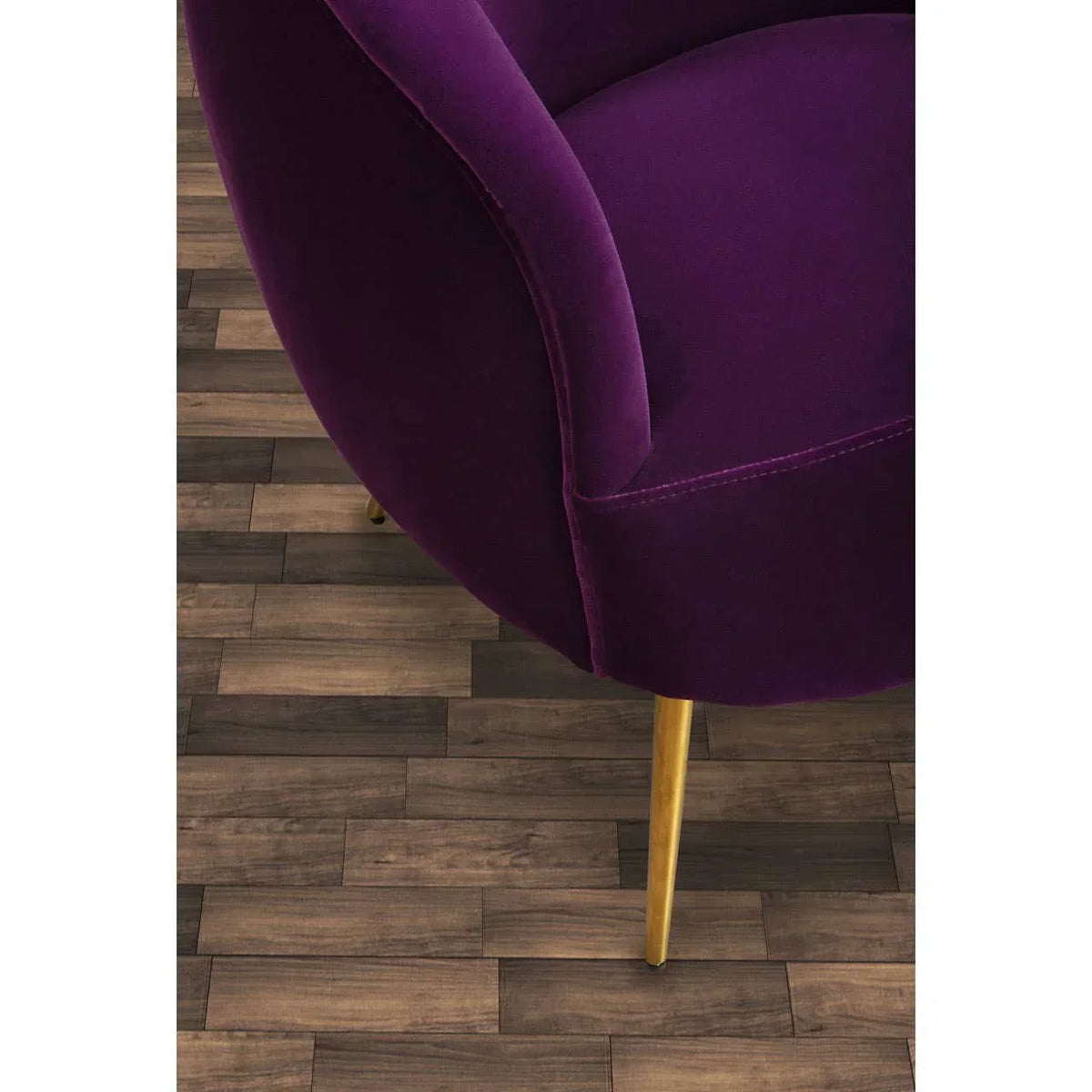 Purple velvet armchair with gold metal legs on wood flooring, partial side view