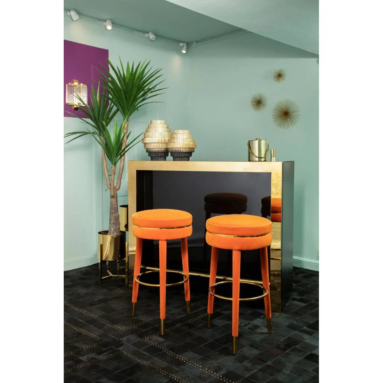 Pair of orange velvet bar stools with gold accents in modern living room setting