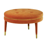 Round footstool upholstered in vibrant orange velvet, featuring a tufted top and four wooden legs with gold accents