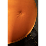 Round footstool upholstered in vibrant orange velvet with a tufted center, showcasing a smooth, soft texture. The footstool is positioned against a dark surface, highlighting its rich color and plush design